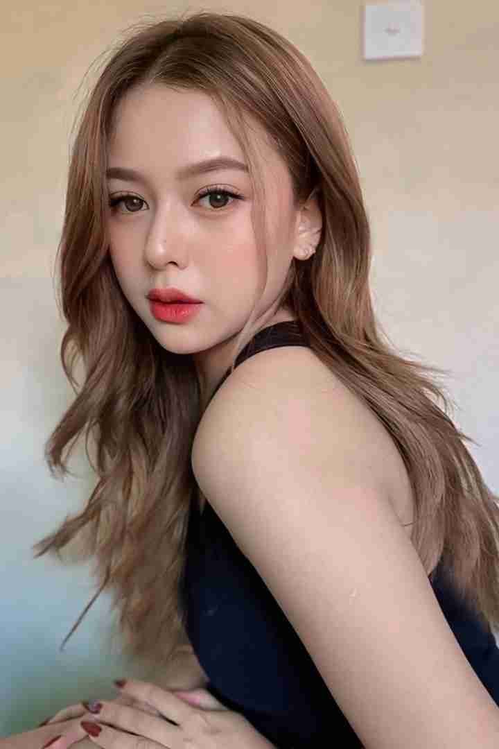 KL Escort Girl Portrait of a beautiful woman with long brown hair wearing a black top. Sex Service Malaysia