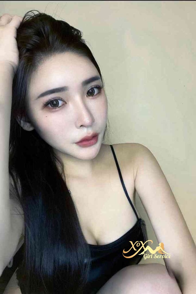 Attractive Asian woman with long black hair in a black top. Portrait with soft lighting.