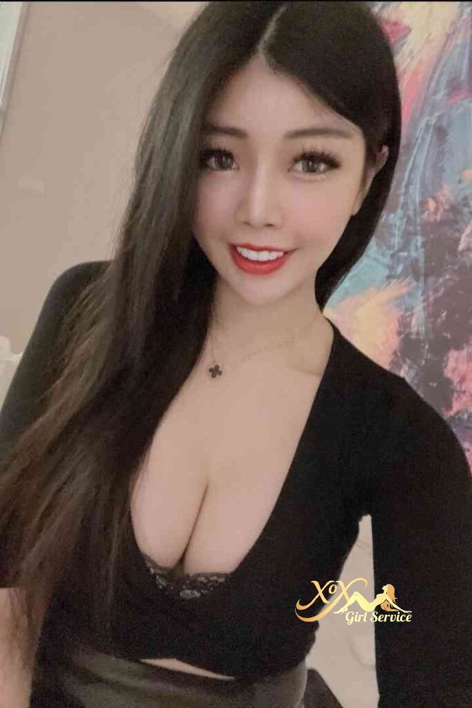 Attractive Asian woman with long dark hair, red lipstick, and a black top.