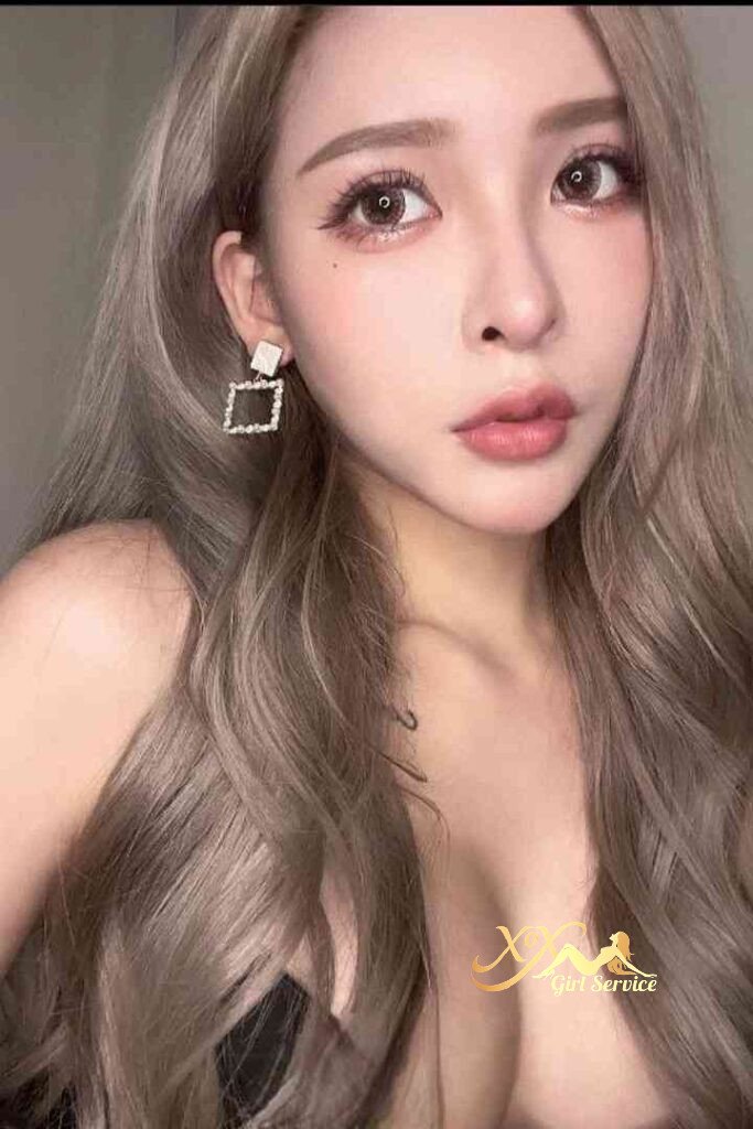 Attractive Asian woman with blonde hair, square earrings, and a subtle tattoo.