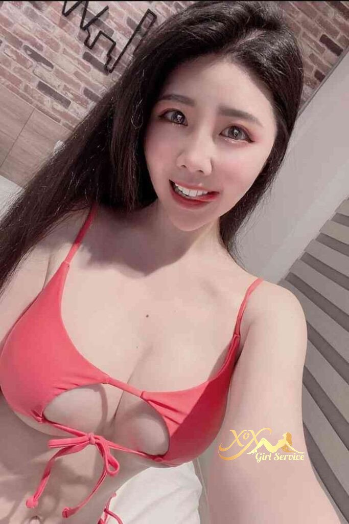 Smiling Asian woman in red bikini top. KL escort Mei Qing.