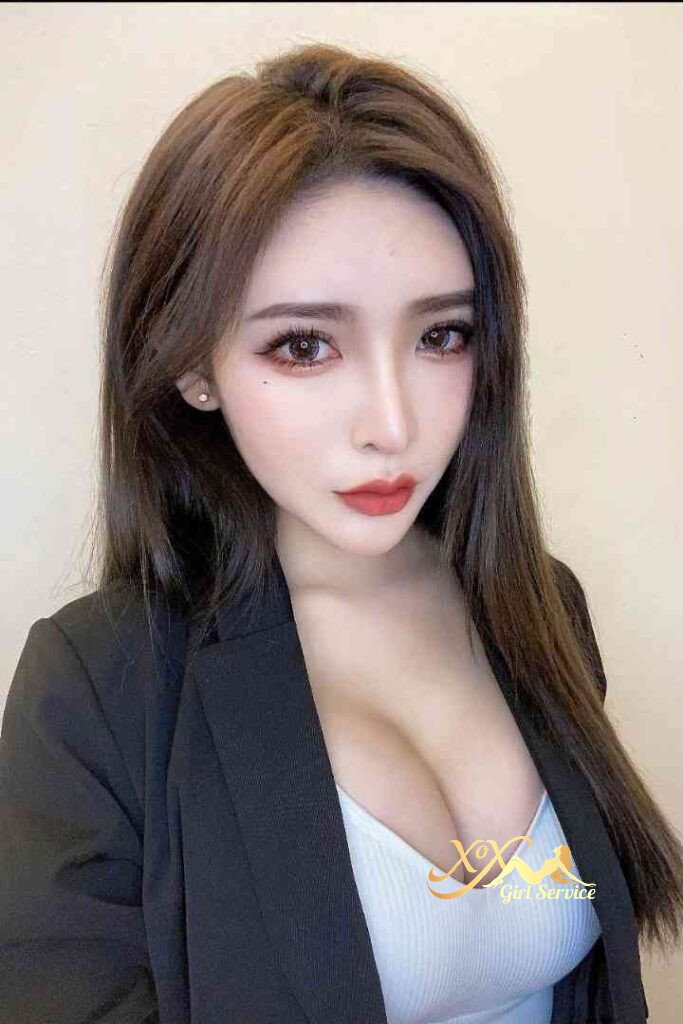 Attractive Asian woman in blazer, red lipstick, and white top.