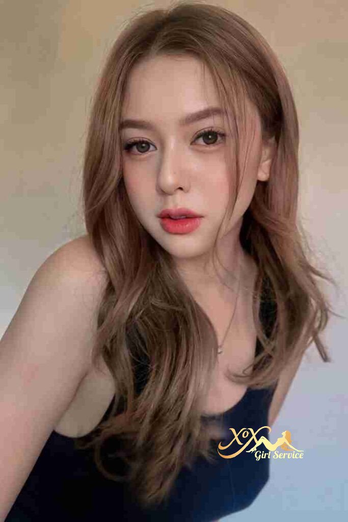 Beautiful Malay woman with wavy brown hair and coral lipstick.