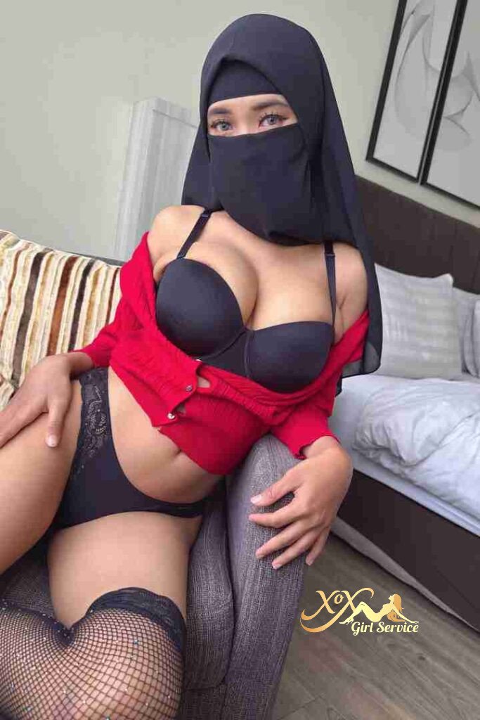 Malay woman in hijab and lingerie sitting on chair. D cup escort.