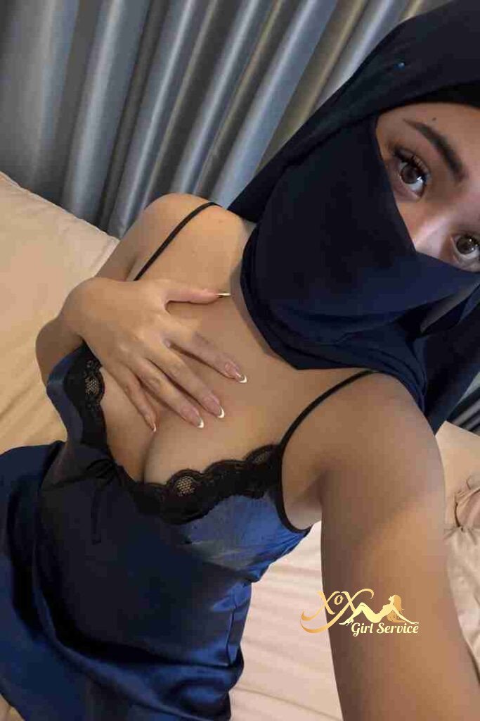 Malay woman in hijab and lingerie, bedroom setting.