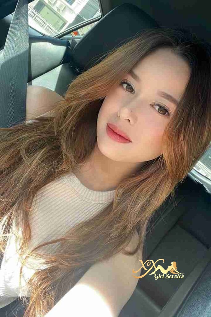 Beautiful Malay woman in car, light brown hair. KL escort service.