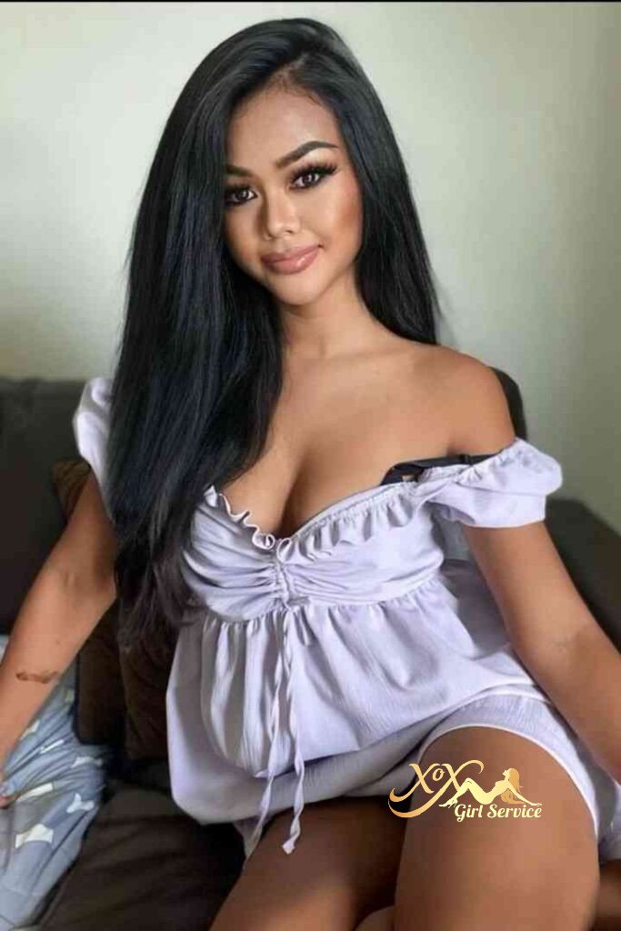 Sophia, Thai escort in KL, wearing a light purple off-shoulder top, looking at the camera.