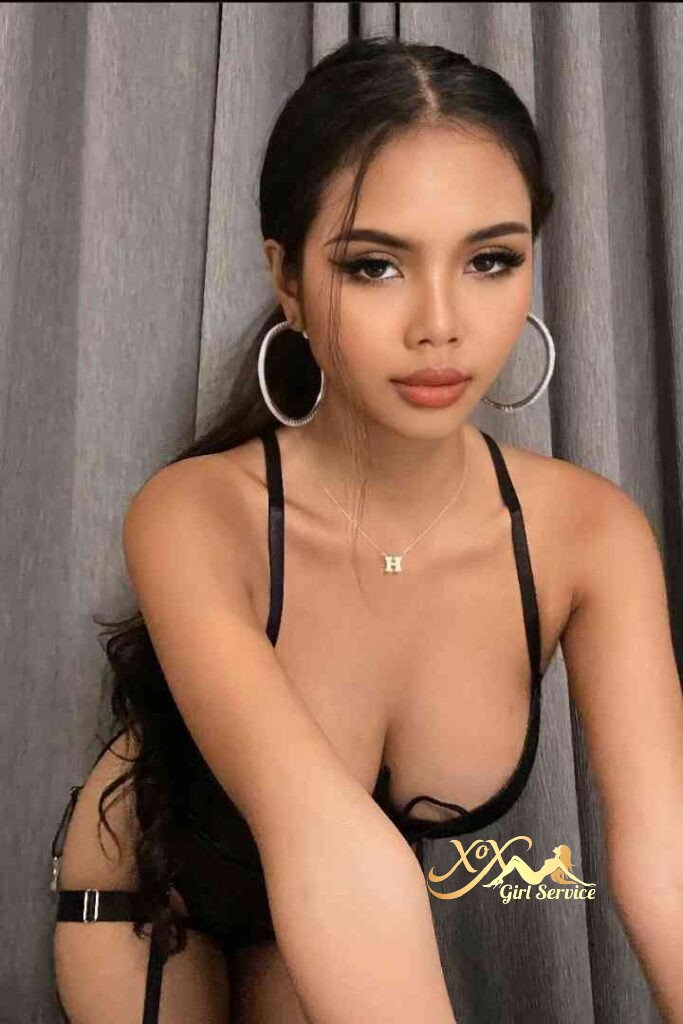 Seductive Thai escort Vanessa in lingerie with hoop earrings and necklace.