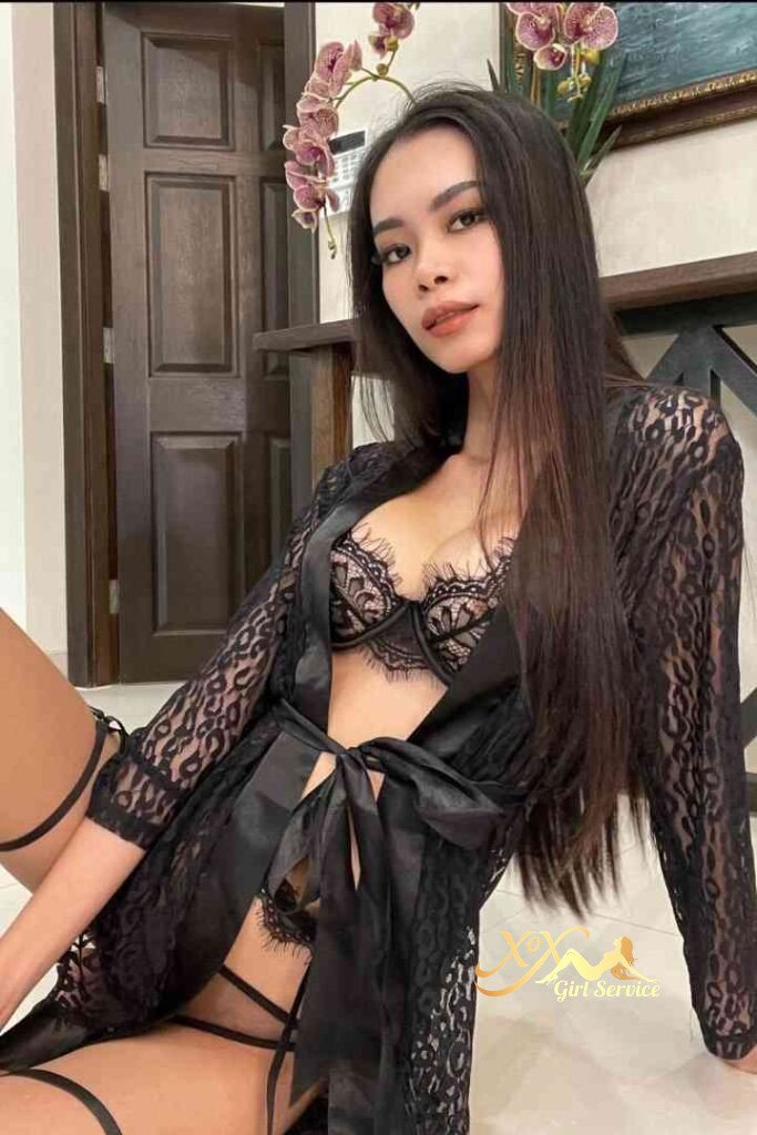 Seductive Thai woman in black lace lingerie and robe, posing indoors.