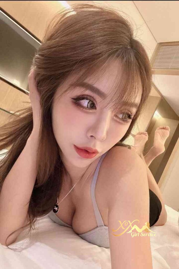 Beautiful Vietnamese woman with C cup curves lying on bed. Incall/outcall escort.