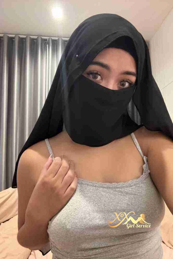 Woman in hijab and tank top. Eyes visible.