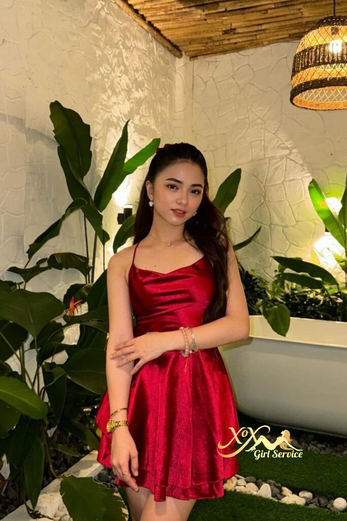 Woman in red dress posing; Zanis escort in KL.